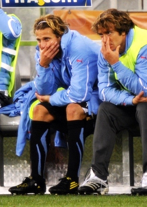  Diego Forlan and Diego Lugano watch the last frantic minutes from the bench