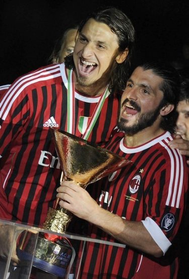 AC Milan's Ibrahimovic and teammate Gattuso celebrate with the trophy after winning their 18th Italian Serie A title at the end of their match against Cagliari at the San Siro stadium in Milan