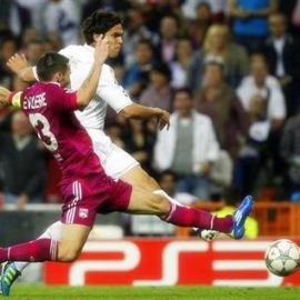 Real Madrid's Kaka shoots past Olympique Lyon's Reveillere during their Champions League soccer match at Real Madrid's Santiago Bernabeu stadium