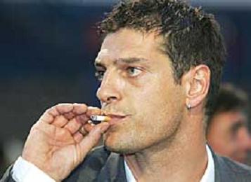 Croatia coach Slaven Bilic coolly puffs away at a cigarette.