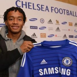 Juan Cuadrado holding a Chelsea shirt after completing his transfer