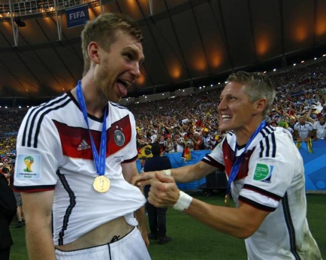 Germany's Per Mertesacker celebrates with Bastian Schweinsteiger after winning their 2014 World Cup final against Argentina at the Maracana stadium in Rio de Janeiro