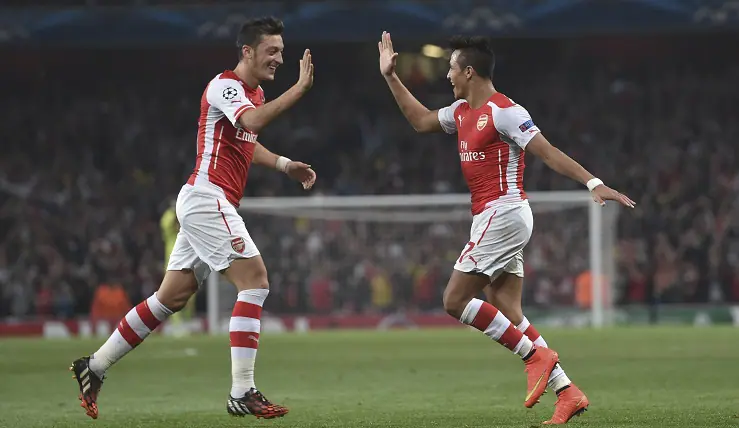 Arsenal's Alexis Sanchez, right, celebrates after scoring against Galatasaray with his teammate Mesut Ozil during the Champions League Group D soccer match between Arsenal  and Galatasaray , at the Emirates Stadium in London, on Wednesday, Oct 1, 2014. (AP Photo/ Tim Ireland)