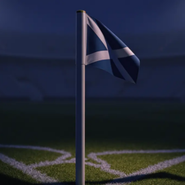 Empty stadium corner during evening floodlighting with navy-blue atmospheric mood and dramatic shadows across pitch markings.