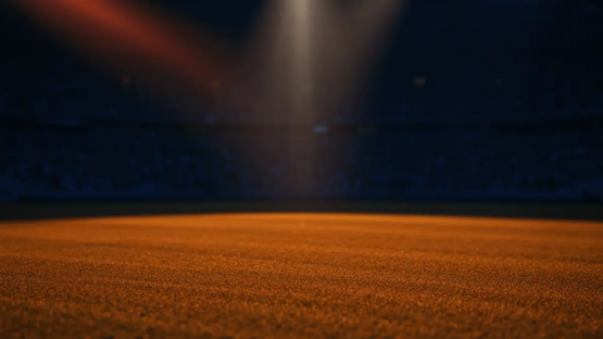 Floodlit stadium at dusk with packed stands, dramatic shadows on pitch, warm golden-hour lighting and atmospheric bokeh