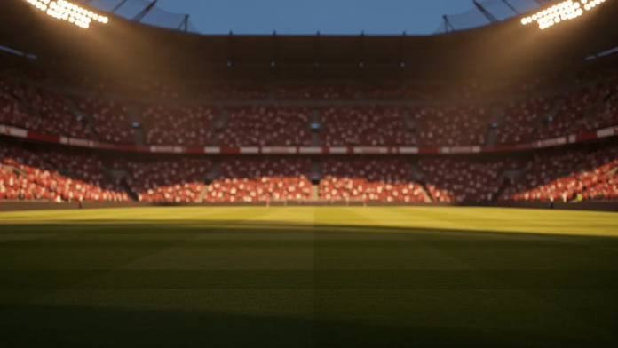 Empty floodlit football pitch at dusk with packed stadium stands bathed in dramatic lighting under golden-hour glow.